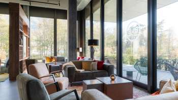 Un espace salon accueillant au B&B HotelEschen des fauteuils et des canapés