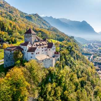 Château de Vaduz au Liechtenstein en automne doré, avec vue sur la vallée du Rhin alpin et la ville de Vaduz