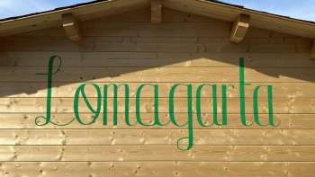Vue sur le logo vert de Lömagarta, qui s'affiche avec style sur la façade en bois de l'agréable Biergarten.