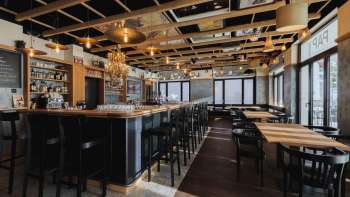 Intérieur lumineux du St. Martins Pub avec bar, mobilier en bois et grandes baies vitrées