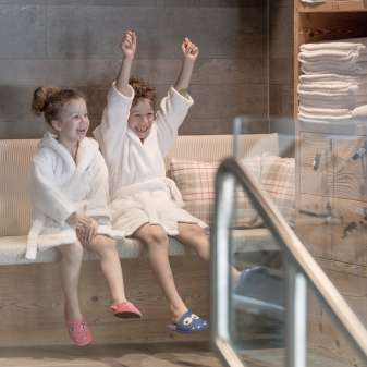 Deux enfants en peignoir profitent de l'espace bien-être de l'hôtel Gorfion - des vacances en famille avec un facteur de bien-être à Malbun.