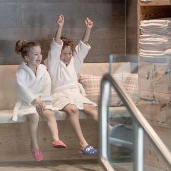 Deux enfants en peignoir profitent de l'espace bien-être de l'hôtel Gorfion - des vacances en famille avec un facteur de bien-être à Malbun.