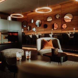 Restaurant Tenn aménagé avec style dans l'hôtel kommod, avec une cheminée, un éclairage élégant et des meubles de salon confortables.
