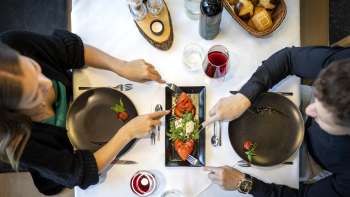 Un couple savoure une entrée à base de tomates et de mozzarella