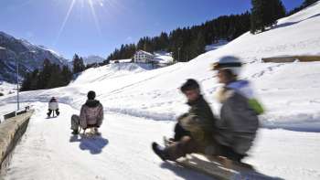 Enseignants Faire de la luge par une belle journée ensoleillée dans un paysage hivernal.