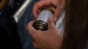 Deux femmes avec un iPad résolvent des énigmes dans l'Outdoor Adventure Room à Malbun dans un décor alpin