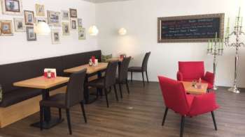  Café confortable avec des sièges modernes, un mur d'images décoratif et un sol en bois chaleureux