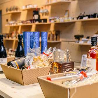 Sélection de vins régionaux et de coffrets cadeaux au Liechtenstein Center à Vaduz, présentés sur une table en bois