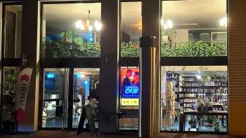 Vue extérieure éclairée du cinéma Skino à Schaan la nuit, avec de grandes baies vitrées et une atmosphère accueillante.