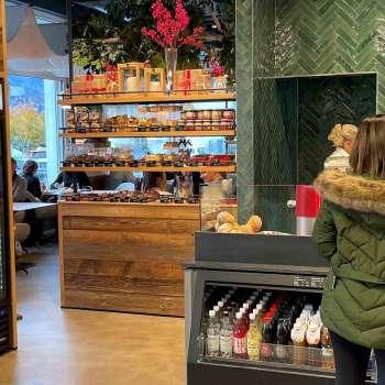 Des clientes à la caisse, entourées d'une décoration en bois accueillante et de produits frais