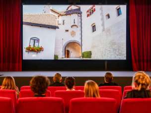 Les visiteurs de l'ancien cinéma de Vaduz regardent un film avec des images du Liechtenstein