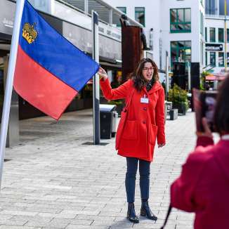 Une guide présente le drapeau du Liechtenstein lors d'une visite guidée dans le centre de Vaduz