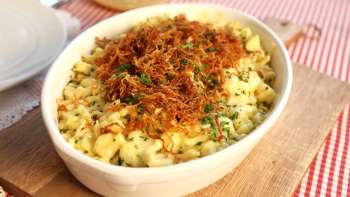 Käsknöpfle traditionnels avec oignons frits - servis dans une assiette sur une planche en bois