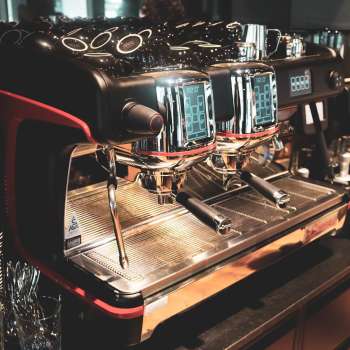 Machine à café dans le restaurant avec une surface en acier inoxydable brillante et des accents rouges