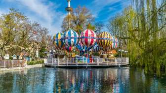 Aperçu du vol en montgolfière du Liechtenstein à Europa-Park, avec des ballons colorés au-dessus d'un lac, entouré d'arbres et d'attractions