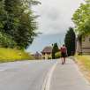 Randonneur avec sac à dos sur le trottoir à Schaanwald au début de l'étape vers Ruggell sur le « sentier du Liechtenstein »