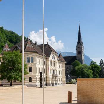  Vue à travers un arc en plein cintre sur le quartier du gouvernement à Vaduz avec le bâtiment du parlement régional et la cathédrale St Florin.
