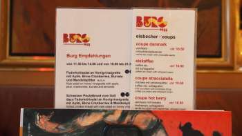Menu de la Brasserie Burg devant une fresque murale colorée - art culinaire et art au cœur de Vaduz.