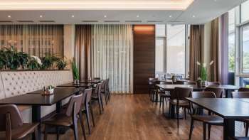 Restaurant Kommod à l'aménagement moderne, avec un intérieur en bois sombre et des banquettes rembourrées.