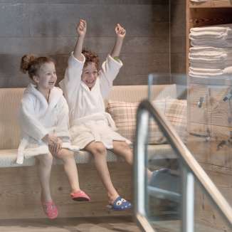 Deux enfants en peignoir profitent de l'espace bien-être de l'hôtel Gorfion - des vacances en famille avec un facteur de bien-être à Malbun.