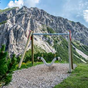 Balançoire suspendue sur le Sentier des balançoires Malbun avec vue sur les falaises abruptes et le paysage alpin au Liechtenstein