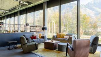Un espace salon accueillant au B&B HotelEschen des fauteuils et des canapés
