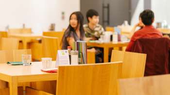 Les clients sont assis à des tables en bois dans le café du musée d'art, discutent de manière détendue et apprécient l'atmosphère. Les clients sont assis à des tables en bois dans le café du musée d'art, discutent de manière détendue et apprécient l'atmosphère.