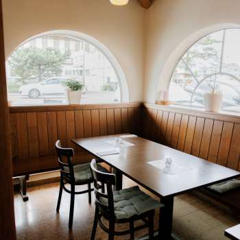 Salle de restaurant accueillante avec des fenêtres claires et un mobilier en bois rustique