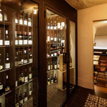 Armoire à vin moderne avec des bouteilles raffinées dans le WY Weinbar stylé WY Weinbar, vue sur la salle de dégustation adjacente.
