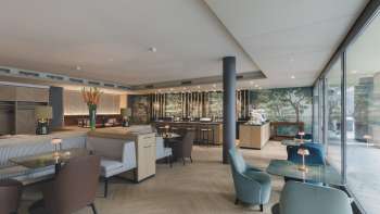 Restaurant moderne avec un intérieur stylé, des fauteuils confortables et de grandes fenêtres qui laissent entrer la lumière du jour. Restaurant moderne avec un intérieur stylé, des fauteuils confortables et de grandes fenêtres qui laissent entrer la lumière du jour.