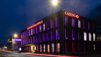 Le casino Schaanwald dans l'obscurité, éclairé de manière impressionnante par des accents de lumière violette - une destination appréciée des noctambules au Liechtenstein.