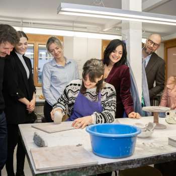 Un groupe de visiteurs intéressés observe une potière en train de modeler - expérience créative dans une atmosphère conviviale à l'atelier de céramique Schädler à Nendeln.