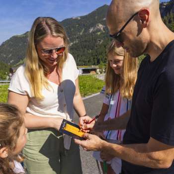 Une famille inscrit des points de minigolf sur une carte de score