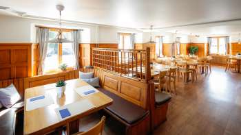 Salle de restaurant lumineuse de style traditionnel avec des boiseries dans le restaurant Rössle.
