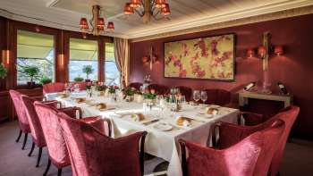 Table dressée avec de la porcelaine fine, des verres et des serviettes sous une lumière naturelle