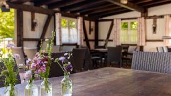 Terrasse confortable avec des meubles en bois et des décorations florales dans des bocaux