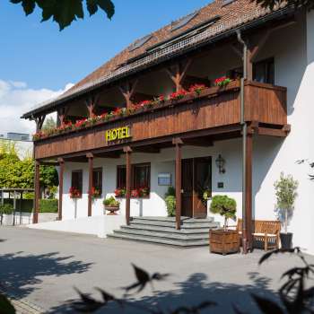 Vue extérieure du restaurant Vivid avec une façade traditionnelle, un balcon en bois et des jardinières fleuries