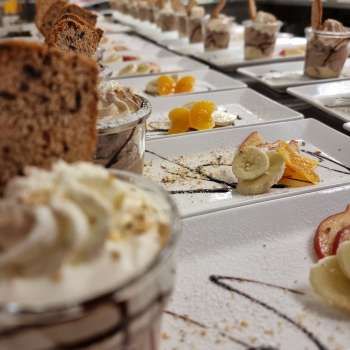 Table richement décorée avec petites coupes à dessert, fruits et garniture pour un buffet sucré