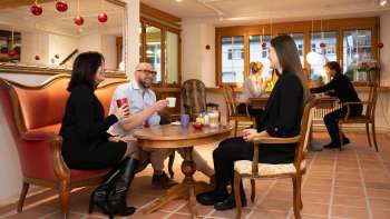 Trois personnes au café céramique du Liechtenstein autour d'un café et d'un thé dans une atmosphère de salon confortable.