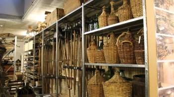 Étagères avec des outils traditionnels, des bouteilles en osier et des objets du quotidien