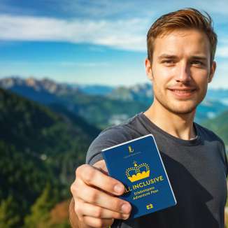 L'homme montre le Passeport découvertes ALL INCLUSIVE avec un panorama de montagnes en arrière-plan