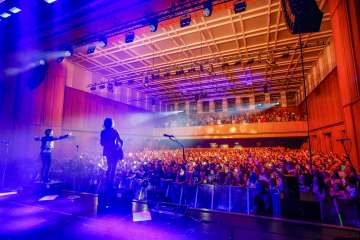 Concert de Silbermond au FL1.Life Festival au SAL de Schaan, avec un public enthousiaste et un éclairage de scène évocateur