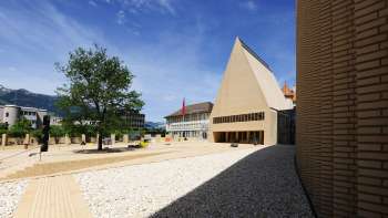 Vue sur la place Peter Kaiser au pavage clair, devant le bâtiment du Landtag à Vaduz, avec son ensemble architectural moderne.