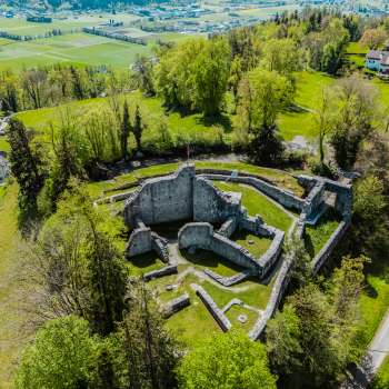 Vue aérienne des ruines du château de Schellenberg, entourées d'une forêt dense et de prairies.