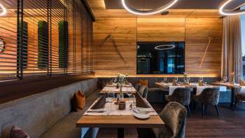 Espace de restauration moderne avec un mobilier en bois noble, des tables élégantes et des fauteuils confortables.