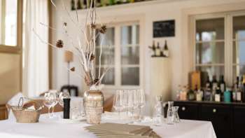 Bar décoratif dans le restaurant Vivid avec des verres et des bouteilles élégants et une ambiance lumineuse naturelle