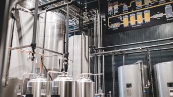 Photo technique détaillée d'un processus de brassage avec tuyauteries, cuves et schéma de fabrication de la bière.
