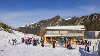 Journée de ski hivernale devant la maison Malbi à Malbun - lieu de rendez-vous pour les cours de ski des enfants dans le domaine skiable familial du Liechtenstein. Journée de ski hivernale devant la maison Malbi à Malbun - lieu de rendez-vous pour les cours de ski des enfants dans le domaine skiable familial du Liechtenstein.