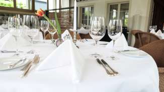 Table dressée avec style, verres, couverts et nappe blanche dans le restaurant haut de gamme Vivid à Triesen, Liechtenstein.
