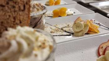 Table richement décorée avec petites coupes à dessert, fruits et garniture pour un buffet sucré
